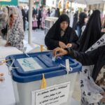 a woman putting a slip of paper into a ballot box